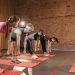 Fitness group performing exercises with dumbbells in a modern yoga studio setting.