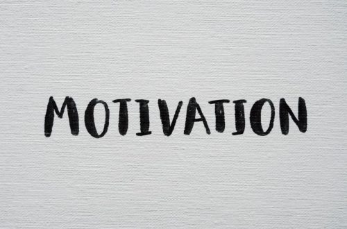 Inspirational word 'Motivation' in black on a white textured canvas background.