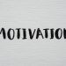 Inspirational word 'Motivation' in black on a white textured canvas background.
